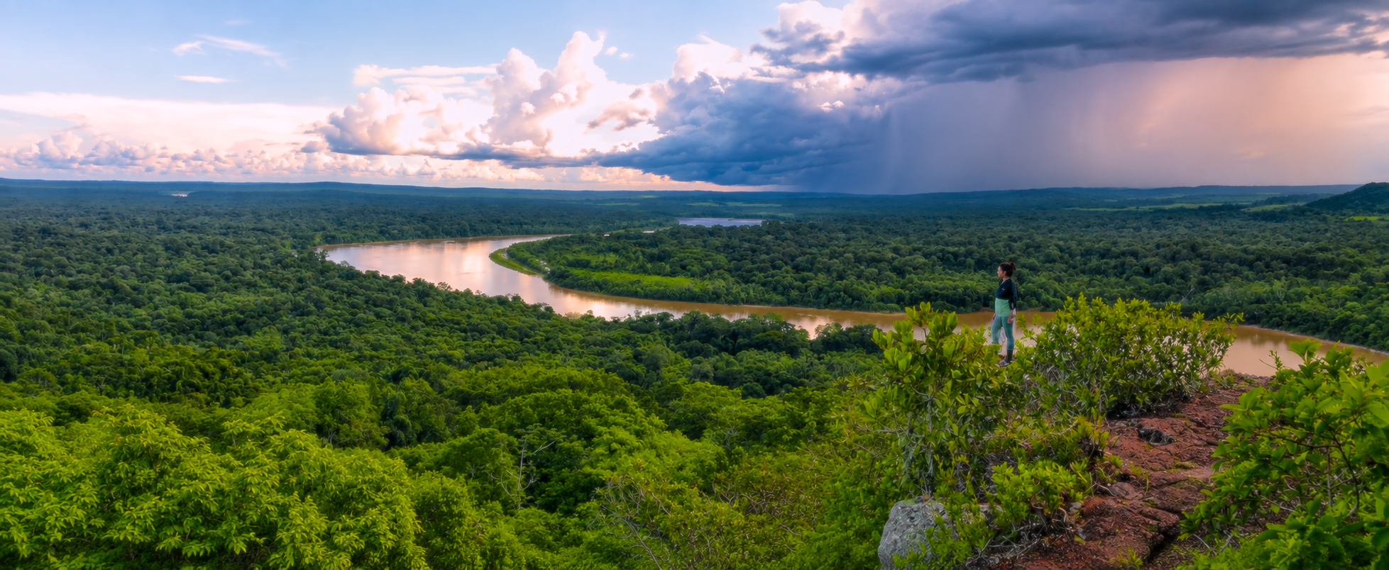 Landscape of forest and river under a dramatic sky